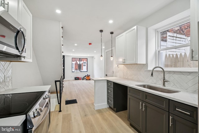 1835 Dudley St, Philadelphia, PA 19145 - kitchen featuring stainless steel appliances, white cabinetry, light wood finished floors, backsplash, and recessed lighting