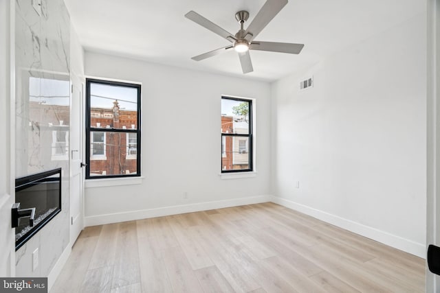 1835 Dudley St, Philadelphia, PA 19145 - unfurnished living room featuring light wood-style floors, ceiling fan, and a high end fireplace