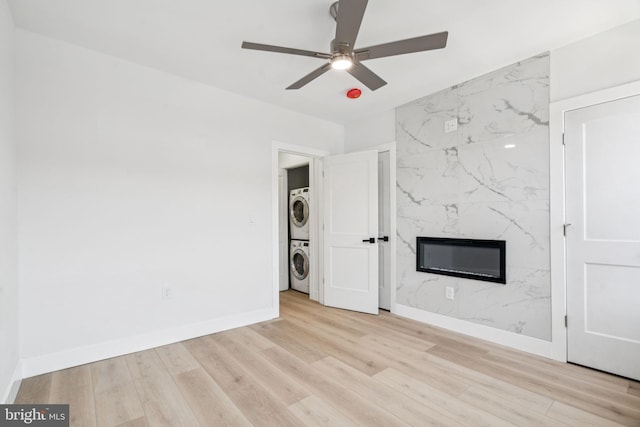 1835 Dudley St, Philadelphia, PA 19145 - unfurnished living room featuring stacked washer / drying machine, a ceiling fan, wood finished floors, and a premium fireplace