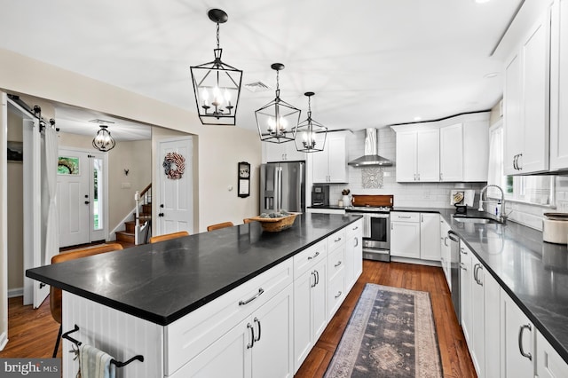 126 Woodview Dr, Doylestown, PA 18901 - kitchen featuring appliances with stainless steel finishes, wall chimney range hood, dark countertops, tasteful backsplash, and recessed lighting