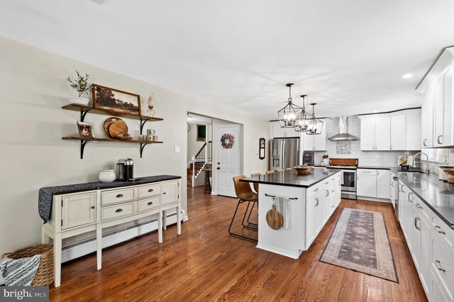 126 Woodview Dr, Doylestown, PA 18901 - kitchen featuring appliances with stainless steel finishes, wall chimney range hood, dark countertops, white cabinets, and dark wood finished floors