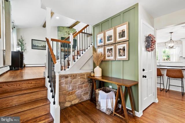 126 Woodview Dr, Doylestown, PA 18901 - stairs featuring wood finished floors, a baseboard heating unit, and a chandelier