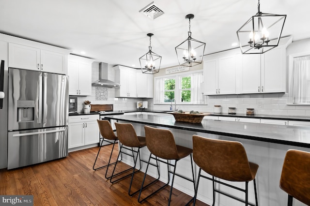 126 Woodview Dr, Doylestown, PA 18901 - kitchen featuring stainless steel refrigerator with ice dispenser, wall chimney range hood, a chandelier, dark countertops, and recessed lighting