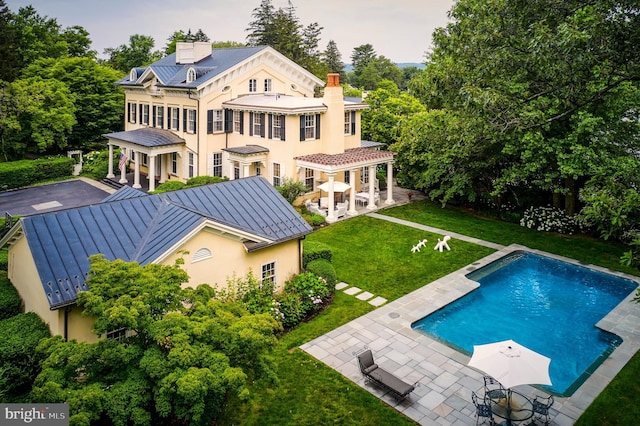 15 Hodge Rd, Princeton, NJ 08540 - back of property featuring a standing seam roof, a chimney, a metal roof, an outdoor pool, and a yard