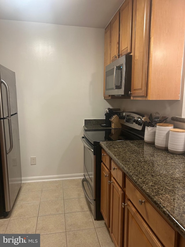3176 Summit Square Dr Unit 4-D7, Oakton, VA 22124 - kitchen featuring stainless steel appliances, brown cabinetry, light tile patterned floors, and dark stone countertops