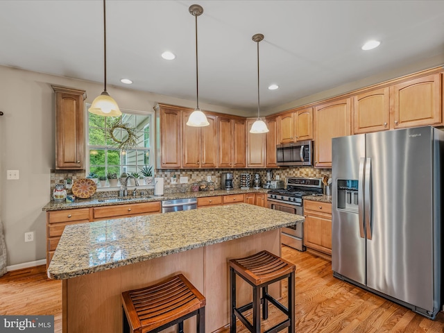 158 Dinwiddie Way, Kearneysville, WV 25430 - kitchen with appliances with stainless steel finishes, a center island, backsplash, light wood-style flooring, and a kitchen breakfast bar