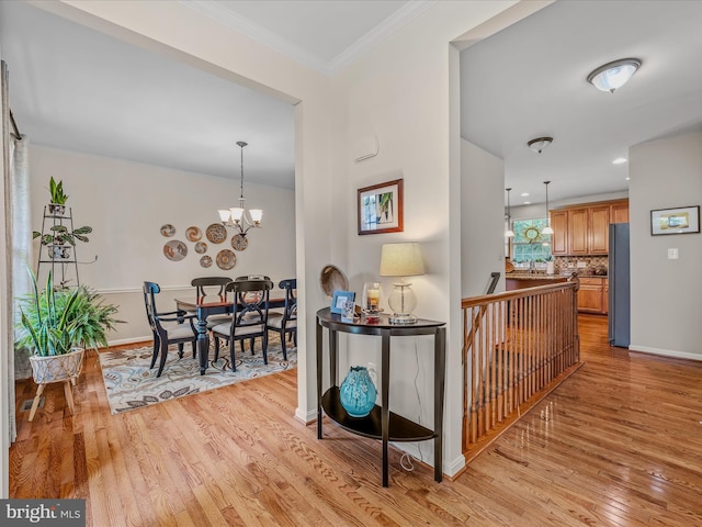 158 Dinwiddie Way, Kearneysville, WV 25430 - hall featuring light wood finished floors, a chandelier, crown molding, and an upstairs landing