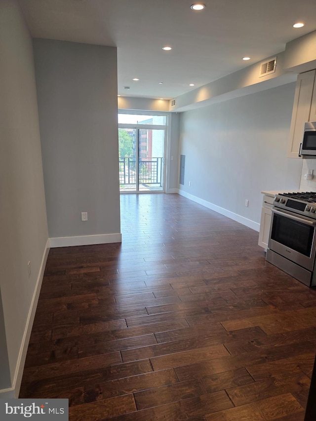 1101 Fern St NW Unit 301, Washington, DC 20012 - kitchen with stainless steel appliances, dark wood-style flooring, white cabinetry, recessed lighting, and light countertops