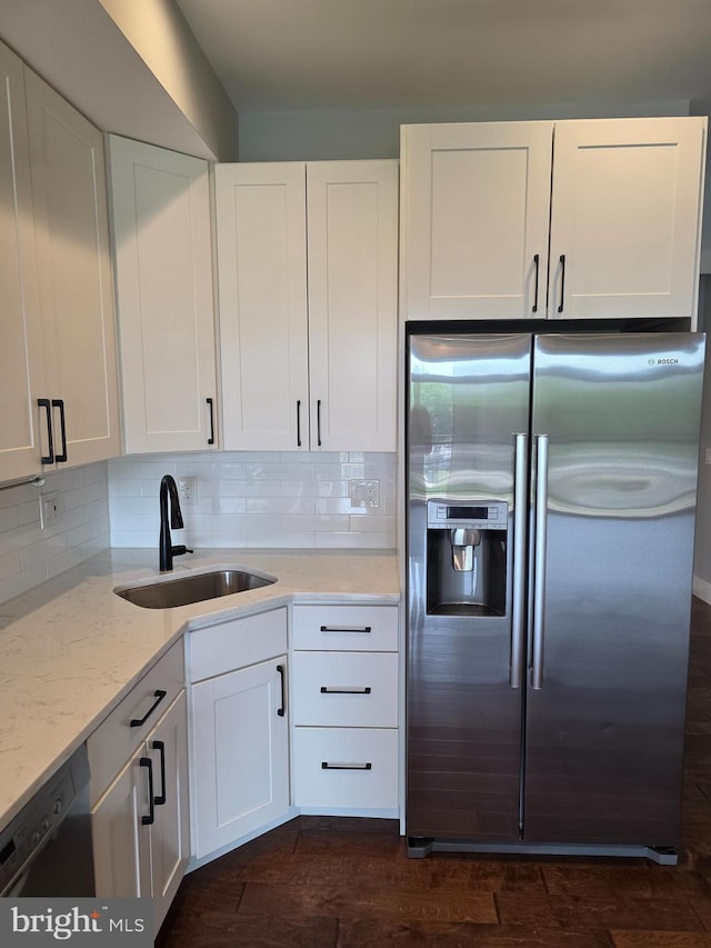 1101 Fern St NW Unit 301, Washington, DC 20012 - kitchen with stainless steel fridge, dishwasher, white cabinets, light stone counters, and backsplash