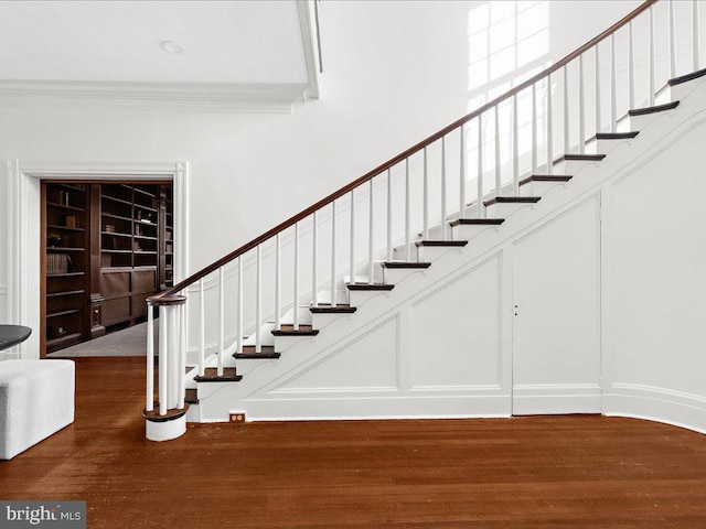 4332 N Charles St, Baltimore, MD 21218 - stairway with wood finished floors, a decorative wall, and crown molding