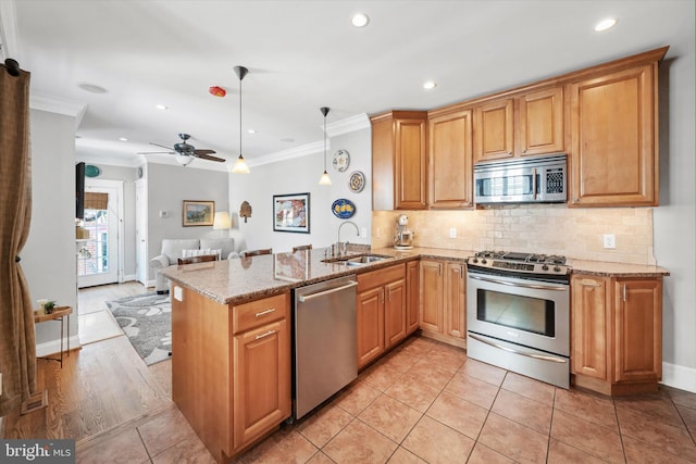 1406 Hamilton St, Wilmington, DE 19806 - kitchen featuring appliances with stainless steel finishes, crown molding, open floor plan, light stone counters, and a peninsula