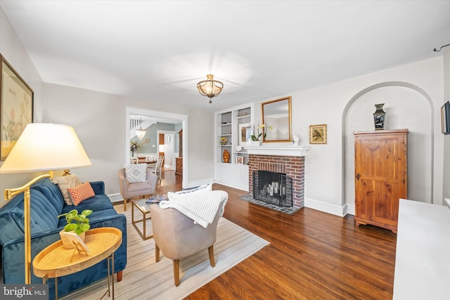 1406 Hamilton St, Wilmington, DE 19806 - living room with wood finished floors, a brick fireplace, built in shelves, and a chandelier