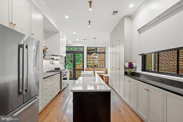 7 U St NW, Washington, DC 20001 - kitchen featuring stainless steel appliances, a center island with sink, backsplash, light wood finished floors, and recessed lighting