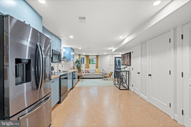 7 U St NW, Washington, DC 20001 - kitchen with stainless steel appliances, butcher block counters, blue cabinets, recessed lighting, and decorative backsplash