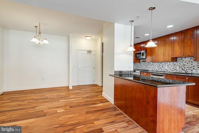 3650 S Glebe Rd Unit 239, Arlington, VA 22202 - kitchen with appliances with stainless steel finishes, light wood finished floors, decorative backsplash, a peninsula, and hanging light fixtures