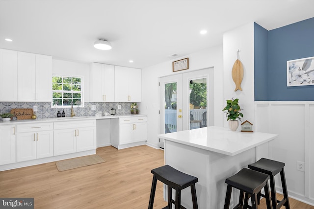 2910 Georgia Ave, Halethorpe, MD 21227 - kitchen featuring a breakfast bar, decorative backsplash, white cabinets, light countertops, and recessed lighting