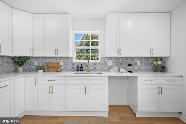 2910 Georgia Ave, Halethorpe, MD 21227 - kitchen with decorative backsplash, white cabinets, and light wood-type flooring