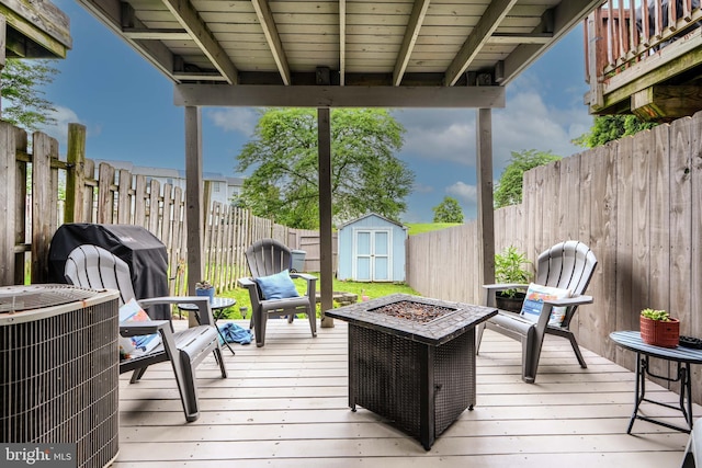 840 W Spring Meadow Ct, Edgewood, MD 21040 - wooden deck featuring a fire pit, a storage unit, a fenced backyard, and a grill