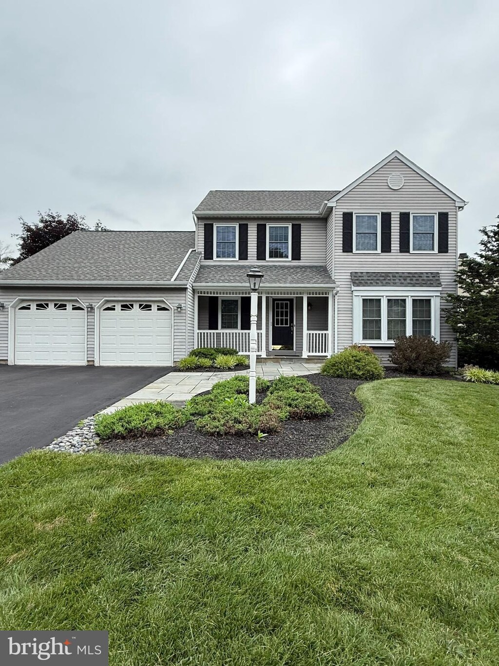403 Mahogany Ct, Doylestown, PA 18901 - traditional-style house featuring an attached garage, covered porch, driveway, a front lawn, and roof with shingles