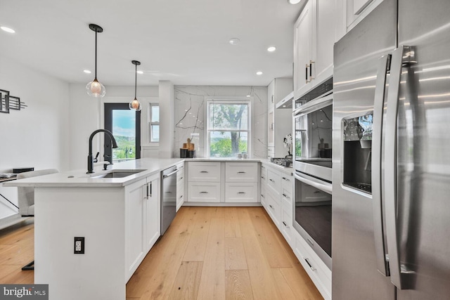 1539 K St SE, Washington, DC 20003 - kitchen featuring stainless steel appliances, light wood-type flooring, a peninsula, recessed lighting, and white cabinetry