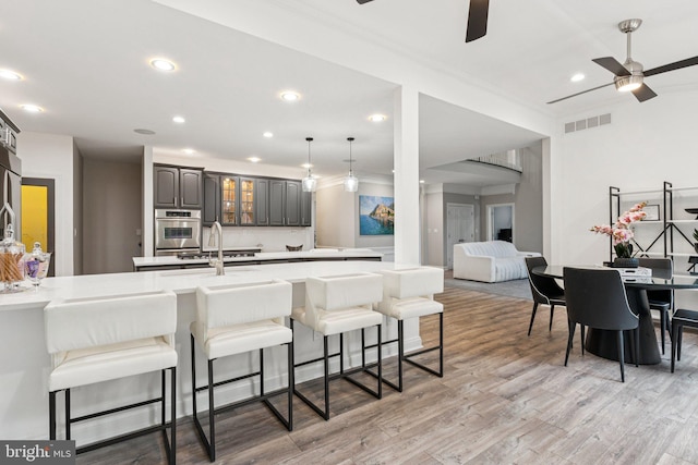 1508 Cornerstone Ct, Crownsville, MD 21032 - kitchen with a ceiling fan, a kitchen breakfast bar, light countertops, light wood-style floors, and recessed lighting
