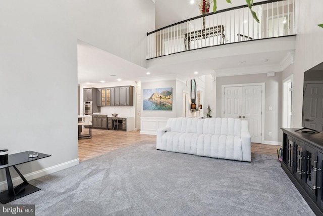 1508 Cornerstone Ct, Crownsville, MD 21032 - living room with light carpet, crown molding, a towering ceiling, light wood-type flooring, and recessed lighting
