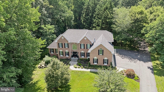 1508 Cornerstone Ct, Crownsville, MD 21032 - view of front facade with brick siding, a front yard, and a view of trees