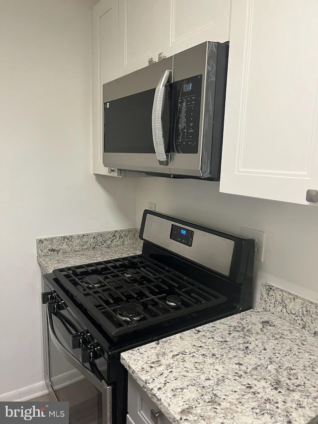 10725 W Dr Unit 301, Fairfax, VA 22030 - kitchen with stainless steel appliances, white cabinetry, and light stone countertops