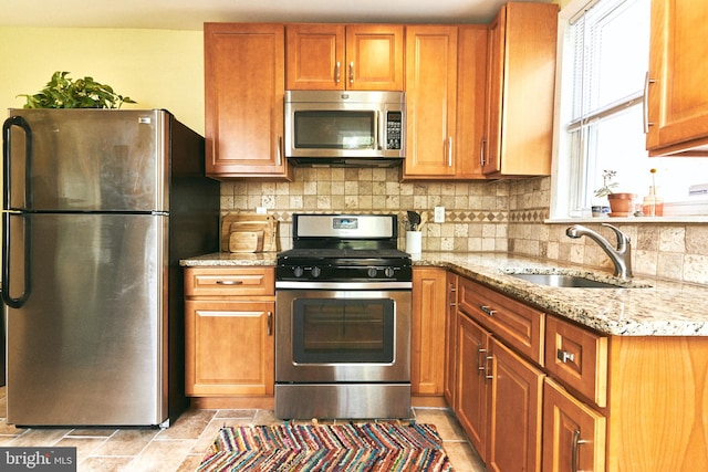 2426 E Indiana Ave, Philadelphia, PA 19134 - kitchen with stainless steel appliances, light stone countertops, backsplash, and brown cabinetry