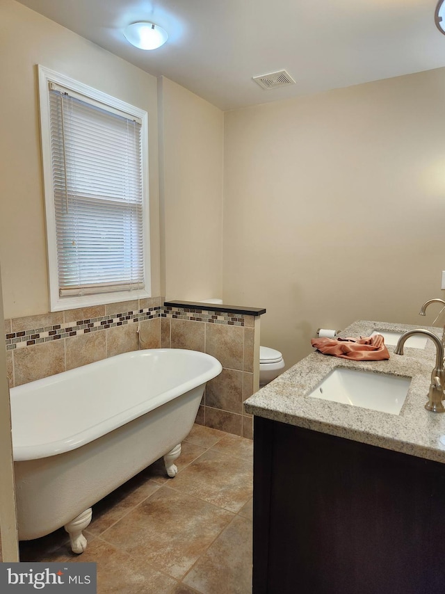 370 Nicholson Rd, Baltimore, MD 21221 - bathroom featuring a freestanding tub, vanity, tile walls, and tile patterned flooring