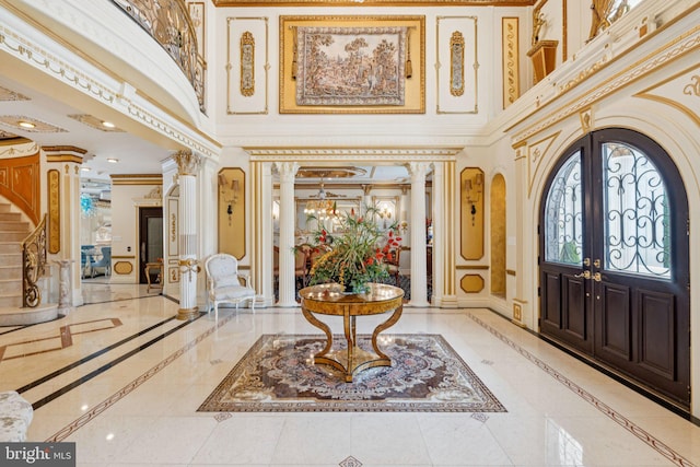423 Seneca Rd, Great Falls, VA 22066 - foyer entrance featuring inlaid floor details, ornate columns, a high ceiling, crown molding, and french doors
