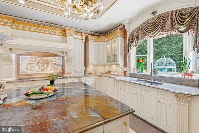 423 Seneca Rd, Great Falls, VA 22066 - kitchen with a chandelier, light stone counters, and glass insert cabinets