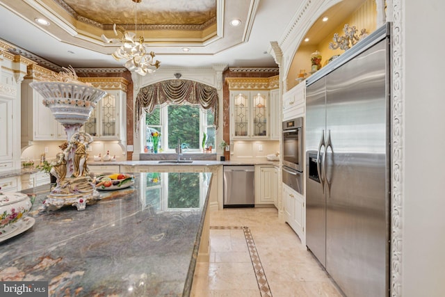 423 Seneca Rd, Great Falls, VA 22066 - kitchen with appliances with stainless steel finishes, inlaid floor details, a chandelier, a tray ceiling, and glass insert cabinets