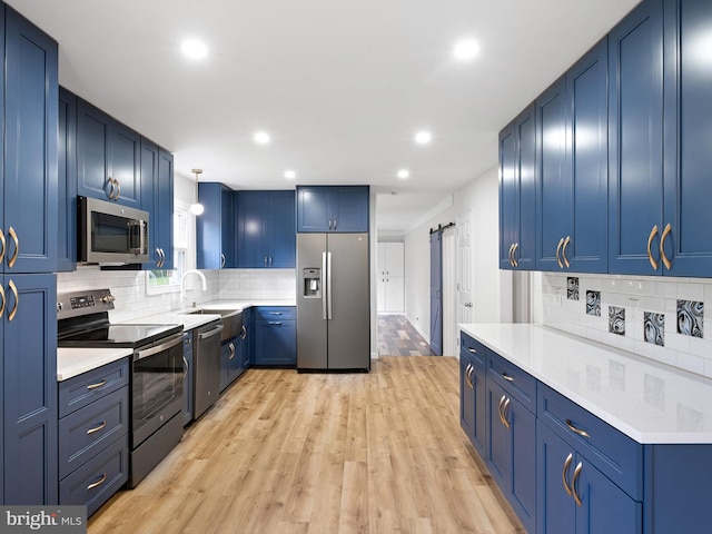 110 Wembley Rd, Wilmington, DE 19808 - kitchen featuring stainless steel appliances, blue cabinets, decorative backsplash, recessed lighting, and light wood-style floors