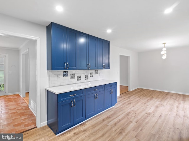 110 Wembley Rd, Wilmington, DE 19808 - kitchen featuring blue cabinetry, decorative backsplash, light countertops, recessed lighting, and light wood finished floors