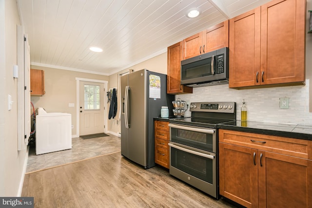 108 W Center St, Kitzmiller, MD 21538 - kitchen featuring stainless steel appliances, washer / dryer, dark countertops, crown molding, and decorative backsplash