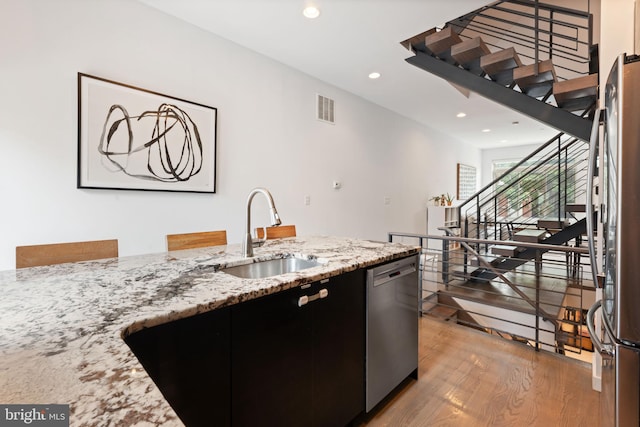 2228 Carpenter St, Philadelphia, PA 19146 - kitchen featuring appliances with stainless steel finishes, light wood-style floors, recessed lighting, dark cabinets, and light stone counters