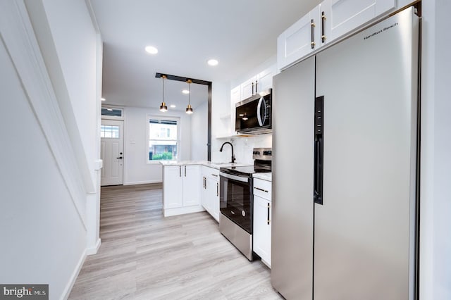 1354 Green St, Reading, PA 19604 - kitchen featuring appliances with stainless steel finishes, light wood finished floors, white cabinets, pendant lighting, and recessed lighting