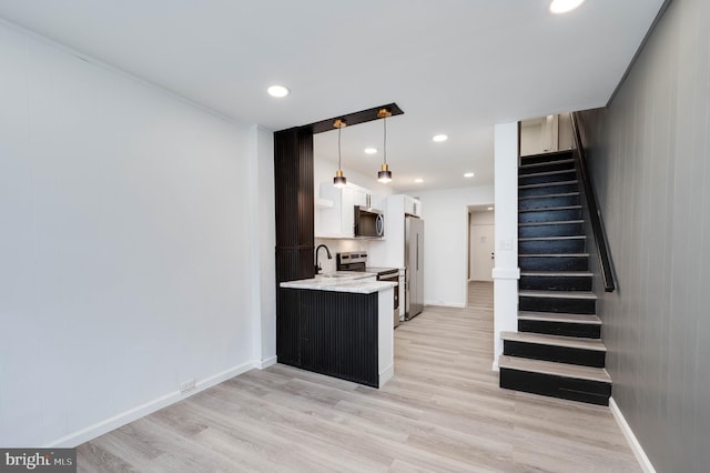 1354 Green St, Reading, PA 19604 - kitchen featuring appliances with stainless steel finishes, light wood finished floors, recessed lighting, white cabinets, and decorative light fixtures