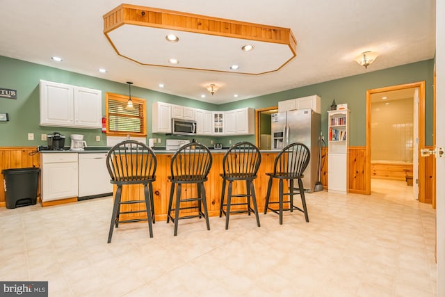 60 Barbaras Way, Mc Henry, MD 21541 - kitchen featuring appliances with stainless steel finishes, dark countertops, white cabinetry, wainscoting, and a breakfast bar