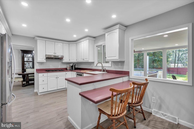 19 Oniontown Rd, Medford, NJ 08055 - kitchen featuring under cabinet range hood, appliances with stainless steel finishes, white cabinets, a breakfast bar area, and a peninsula