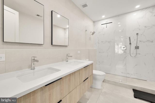 146 S St NW Unit B, Washington, DC 20001 - full bath with tile walls, double vanity, a marble finish shower, and recessed lighting