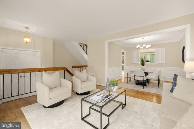 1937 Hickory Hill Ln, Silver Spring, MD 20906 - living room featuring wood finished floors, a chandelier, a wainscoted wall, ornamental molding, and stairway