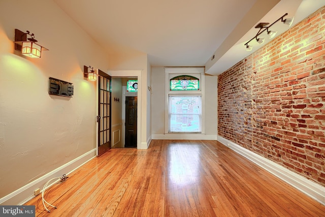 511 S Belnord Ave, Baltimore, MD 21224 - foyer with light wood-type flooring and brick wall