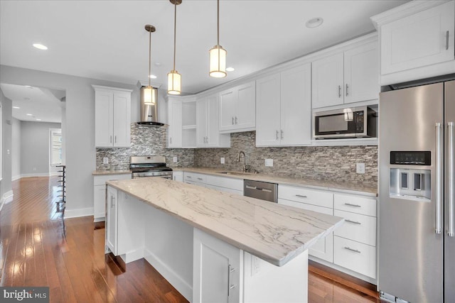 144 Levering St, Philadelphia, PA 19127 - kitchen featuring stainless steel appliances, wall chimney exhaust hood, tasteful backsplash, a center island, and white cabinets
