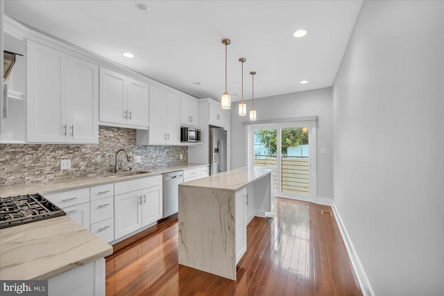 144 Levering St, Philadelphia, PA 19127 - kitchen with appliances with stainless steel finishes, tasteful backsplash, a center island, white cabinets, and light stone counters