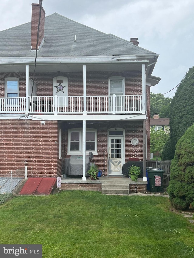 1034 Hamilton Blvd, Hagerstown, MD 21742 - back of house featuring brick siding, a lawn, a balcony, and a chimney