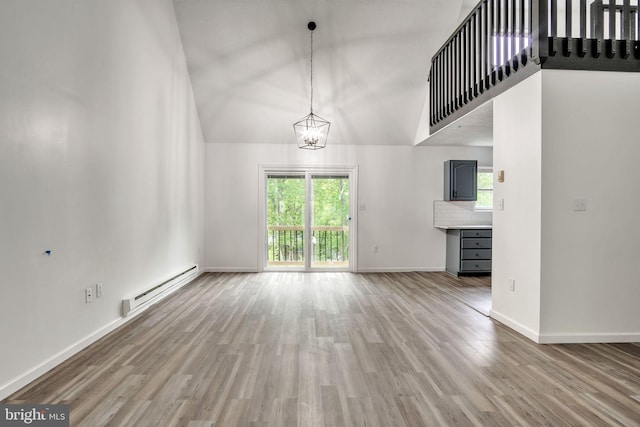 121 Almond Ct, Milford, PA 18337 - unfurnished living room with a baseboard radiator, wood finished floors, a high ceiling, and a chandelier