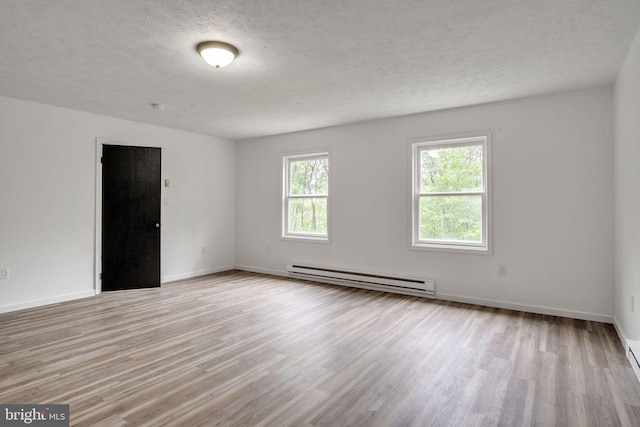 121 Almond Ct, Milford, PA 18337 - empty room featuring baseboard heating, light wood finished floors, a textured ceiling, and a baseboard heating unit
