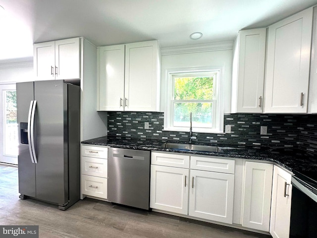 8357 Gannon Cir, Easton, MD 21601 - kitchen with stainless steel appliances, ornamental molding, white cabinetry, light wood-style floors, and dark stone counters